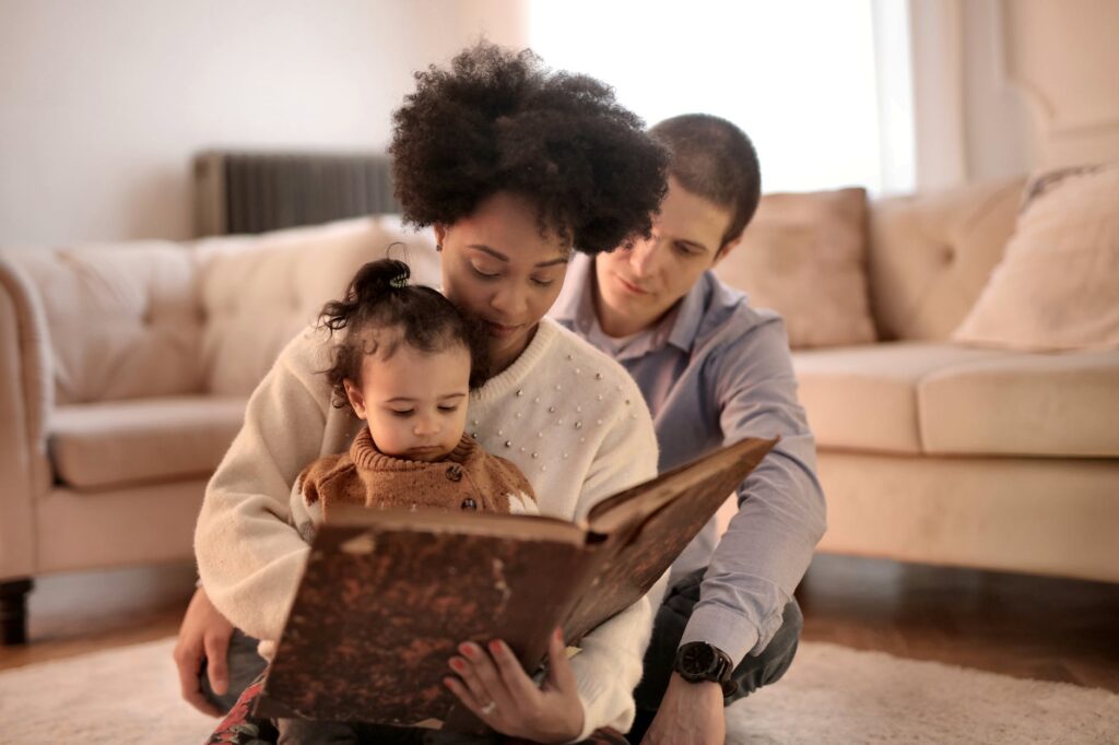 photo of woman holding brown book with her child. National Share-a-Story Month