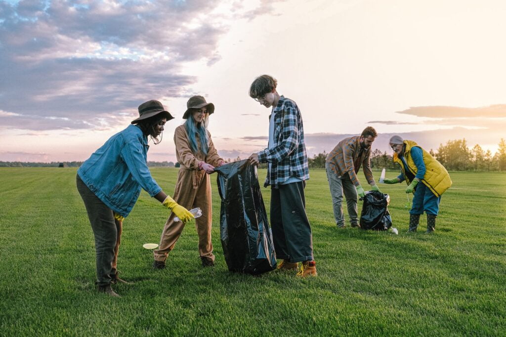 volunteers collecting trash on green grass field. Volunteers' Week books