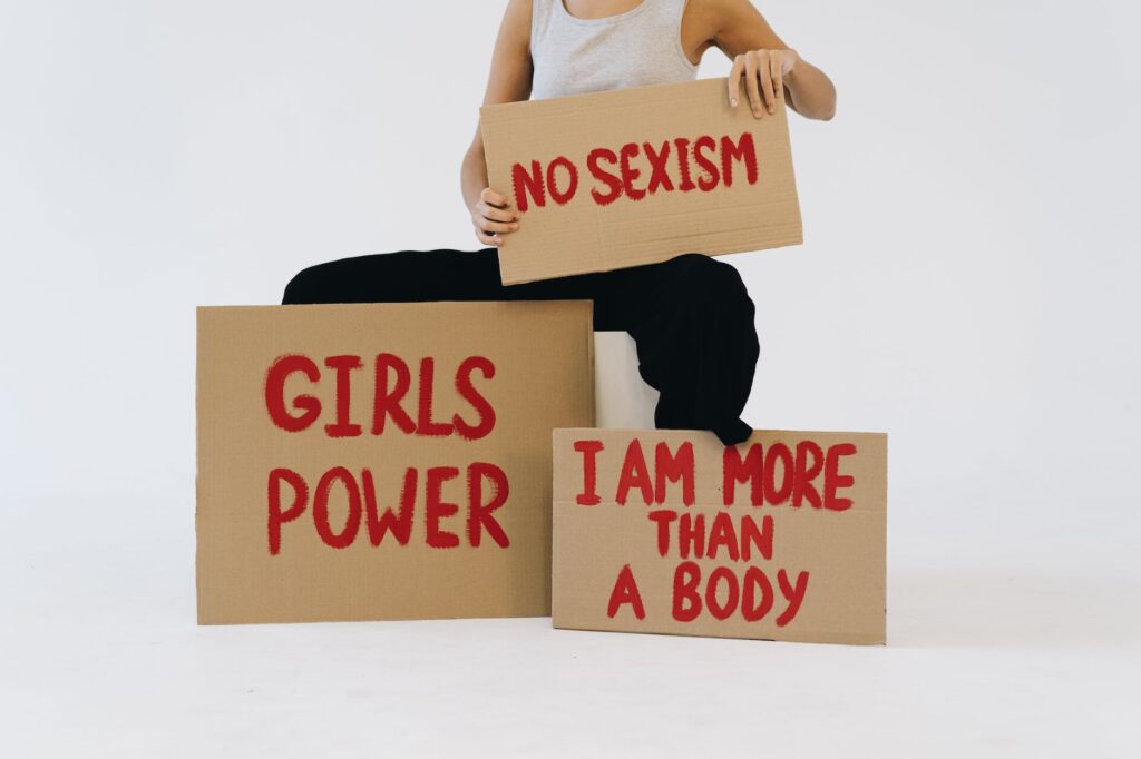 a woman showing three placards. What is Patriarchy