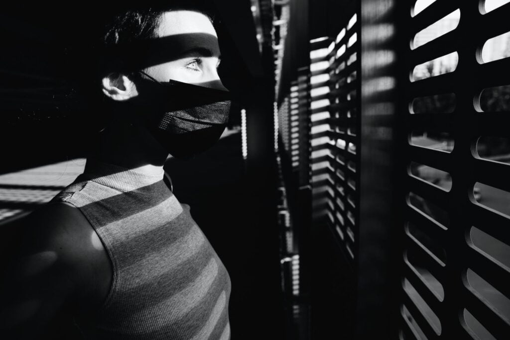 black and white photo of person looking at the window. National Schizophrenia Awareness Day