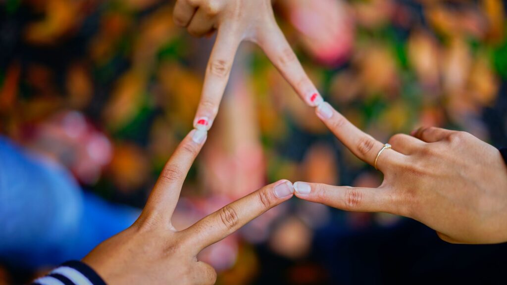photography of people connecting their fingers, as Dr Daniel J. Siegel explains what interconnected and intraconnection means