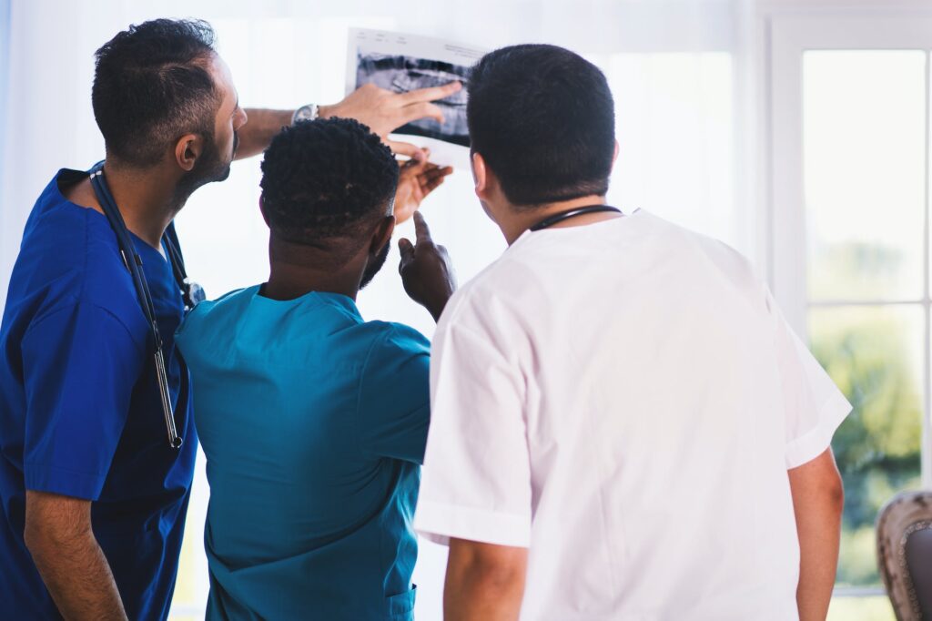 three person looking at x ray result as we look at the health gap