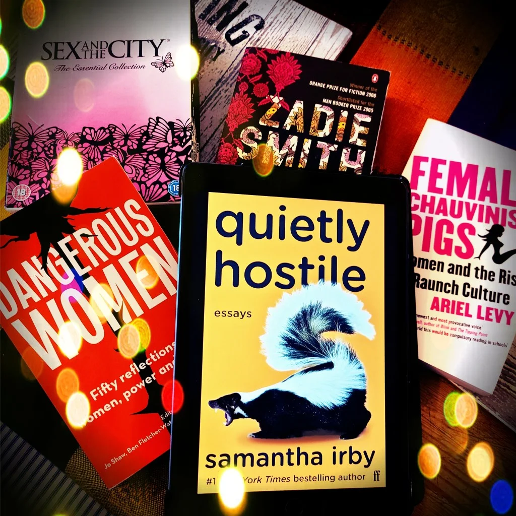 Samantha Irby's Quietly Hostile surrounded by several books and a Sex and the City boxset
