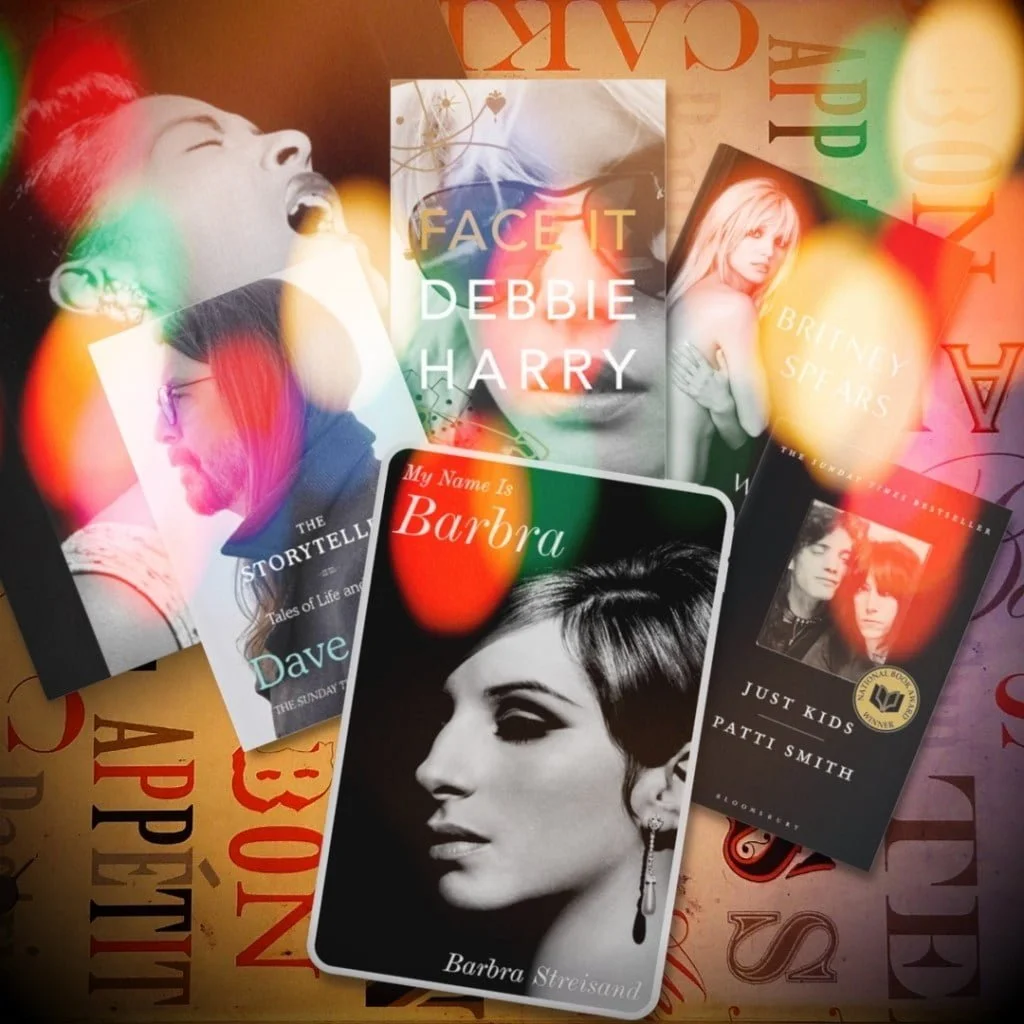Barbra Streisand book "My Name is Barbra" in front of the books "The Storyteller" by Dave Grohl, "Face It" by Debbie Harry, "The Woman in Me" by Britney Spears, "Just Kids" by Patti Smith, and a canvas poster of the artist Billie Holiday singing.